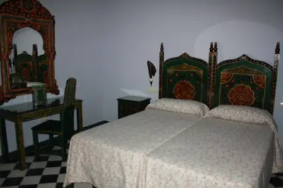 a bedroom with a bed and a table and a mirror at Casa Rural Sidonia in Medina Sidonia