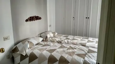 a bedroom with a bed with a comforter on it at Apartamento wifi plaza del caballo in Jerez de la Frontera