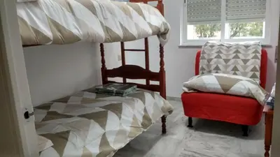 a bedroom with a bunk bed and a chair at Apartamento wifi plaza del caballo in Jerez de la Frontera