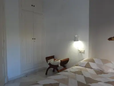 a bedroom with a bed and a chair and a lamp at Apartamento wifi plaza del caballo in Jerez de la Frontera