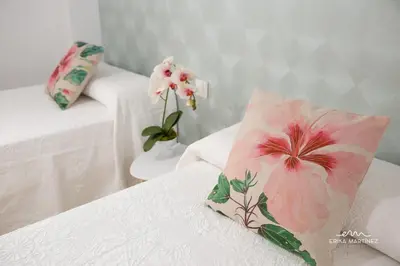 a room with two beds with a pink pillow and flowers at Apartamento Pale Cream MRZ Rentals in Jerez de la Frontera