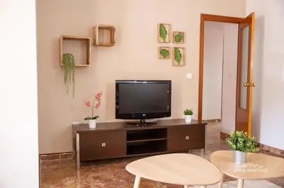 a living room with a television on a cabinet at Apartamento Pale Cream MRZ Rentals in Jerez de la Frontera