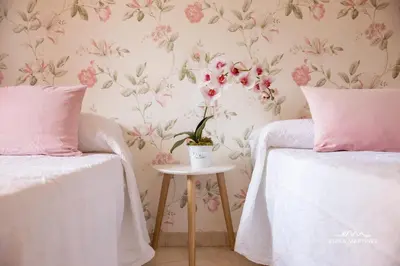 a bedroom with two beds with pink flowers on the wall at Apartamento Pale Cream MRZ Rentals in Jerez de la Frontera