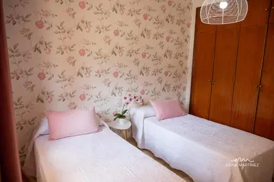 two beds in a room with pink walls at Apartamento Pale Cream MRZ Rentals in Jerez de la Frontera