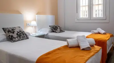a bedroom with two beds with towels on them at Apartamento Amanecer Cadiz in Cádiz