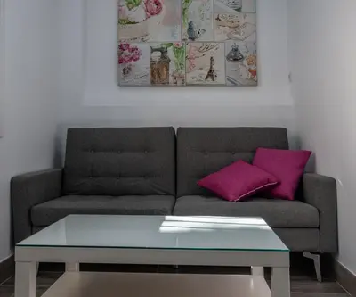 a living room with a couch and a table at Apartamento Amanecer Cadiz in Cádiz