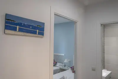 a bathroom with a picture of the ocean on the wall at Apartamento Amanecer Cadiz in Cádiz
