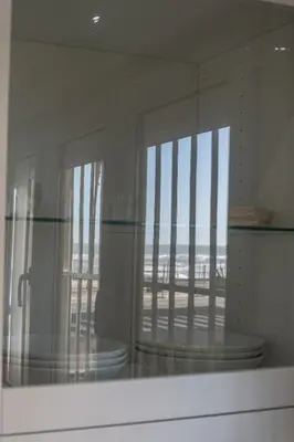 a glass window with a view of the beach at Apartamento Amanecer Cadiz in Cádiz