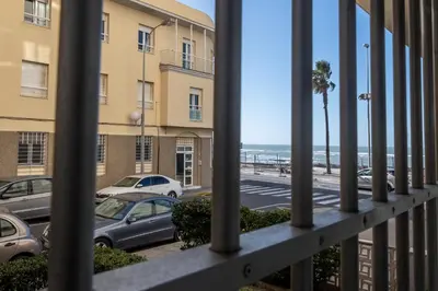 a view of the beach from a balcony of a building at Apartamento Amanecer Cadiz in Cádiz
