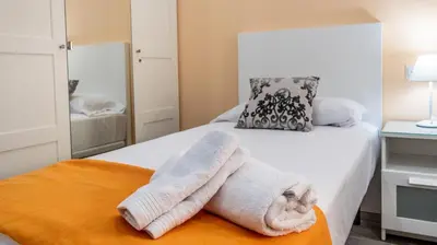 a white towel on a bed in a bedroom at Apartamento Amanecer Cadiz in Cádiz
