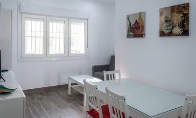 a kitchen and dining room with a table and chairs at Apartamento Amanecer Cadiz in Cádiz