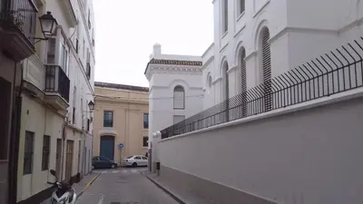 an empty alley with a white building on the side at La casa del dibujante in Cádiz