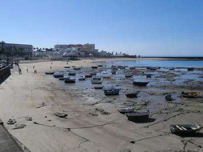 a group of boats sitting on the beach at La casa del dibujante in Cádiz