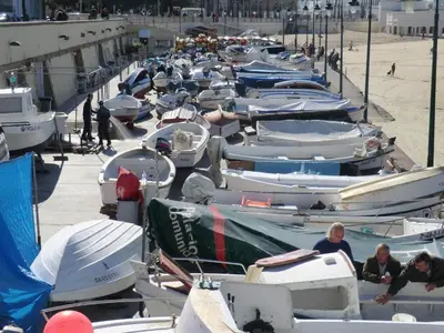 a bunch of boats are lined up on the beach at La casa del dibujante in Cádiz