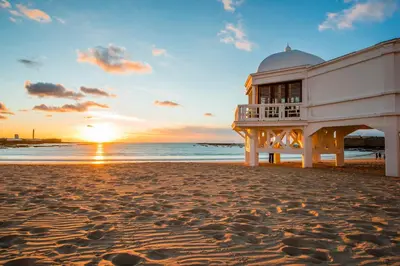 a building on the beach at sunset at La casa del dibujante in Cádiz