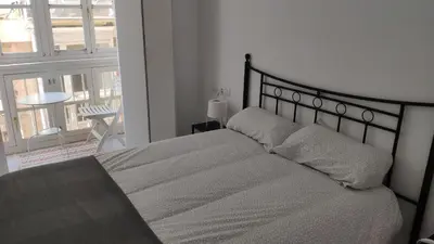 a bedroom with a bed and a large window at Apartamento El Gaditano Errante in Cádiz