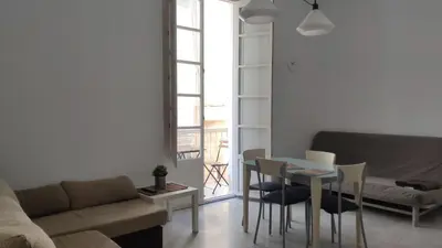 a living room with a couch and a table and chairs at Apartamento El Gaditano Errante in Cádiz