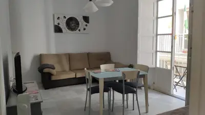 a living room with a table and a couch at Apartamento El Gaditano Errante in Cádiz