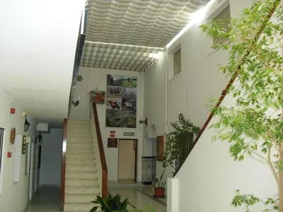 a hallway of a building with stairs and trees at El Faisan C&R Hotel in Arcos de la Frontera