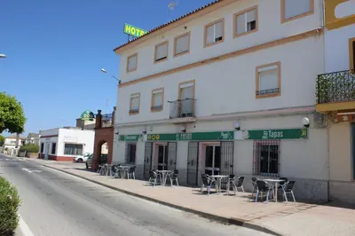 a building with tables and chairs on a street at El Faisan C&R Hotel in Arcos de la Frontera