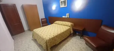 a bedroom with a bed and a desk and a chair at El Faisan C&R Hotel in Arcos de la Frontera