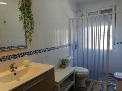 a bathroom with a sink and a toilet and a mirror at Mis Princesas en Casablanca in Chiclana de la Frontera