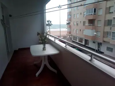 a room with a table and a window with a view of the beach at Azul Maritimo in Cádiz