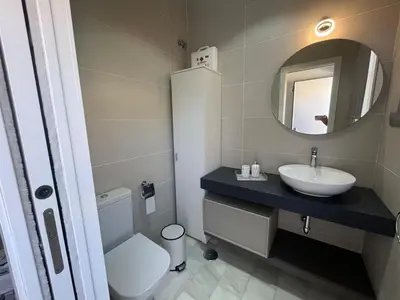 a bathroom with a sink and a toilet and a mirror at PuertoHouse in El Puerto de Santa María