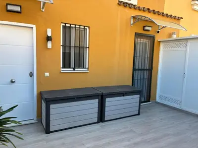 a bench in front of a building with two doors at PuertoHouse in El Puerto de Santa María