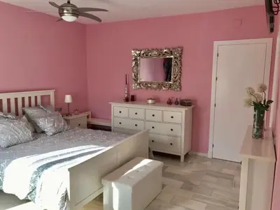 a bedroom with pink walls and a bed and a mirror at PuertoHouse in El Puerto de Santa María