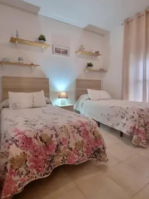 two beds in a room with flowers on them at Apartamento Cayetano in Rota