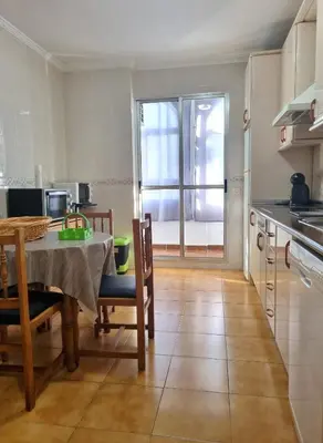 a kitchen and dining room with a table and chairs at Apartamento Cayetano in Rota