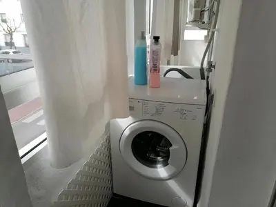 a washing machine with a blue bottle on top of it at Apartamento Cayetano in Rota