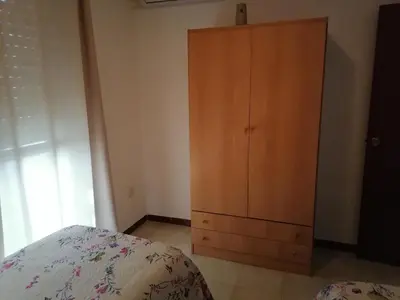 a bedroom with a wooden cabinet and a bed at Apartamento Cayetano in Rota