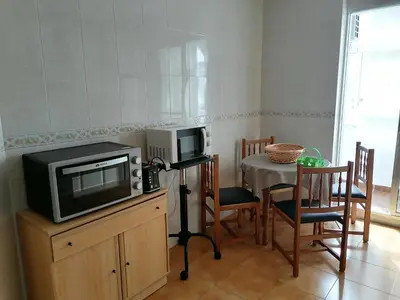 a kitchen with a tv and a table with chairs at Apartamento Cayetano in Rota