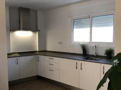 a kitchen with white cabinets and a sink and a window at Vivienda Avenida de la Manzanilla in Sanlúcar de Barrameda