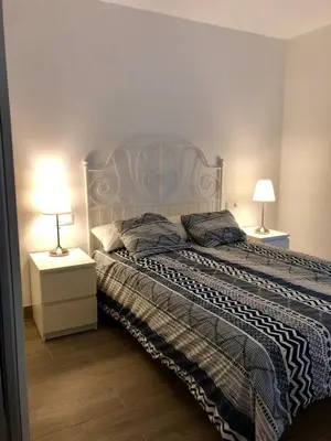 a bedroom with a bed and two lamps on tables at Vivienda Avenida de la Manzanilla in Sanlúcar de Barrameda