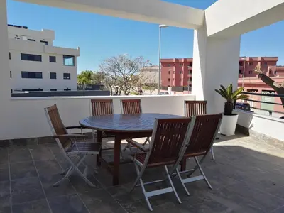 a table and chairs on a balcony with a view at Vivienda Avenida de la Manzanilla in Sanlúcar de Barrameda