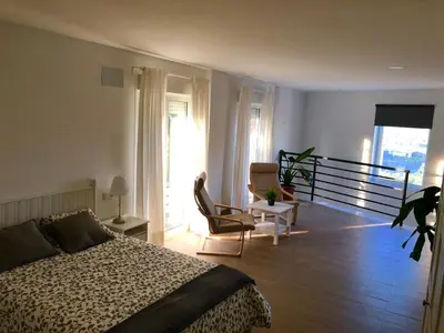 a bedroom with a bed and a balcony at Vivienda Avenida de la Manzanilla in Sanlúcar de Barrameda