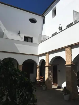an external view of a white building with arches at Posada Alegria in Medina Sidonia