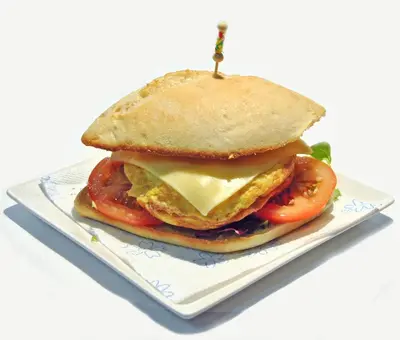a sandwich with cheese and tomatoes on a plate at Pensión San Marcos in Arcos de la Frontera