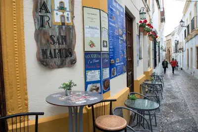 a row of tables and chairs on a street at Pensión San Marcos in Arcos de la Frontera