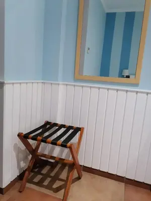 a wooden bench in a room with a blue wall at Hotel Marisma Sancti Petri in Chiclana de la Frontera