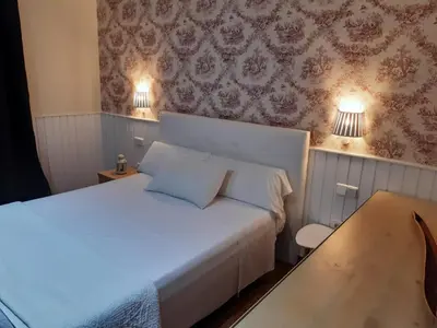 a bedroom with a white bed and two lamps at Hotel Marisma Sancti Petri in Chiclana de la Frontera