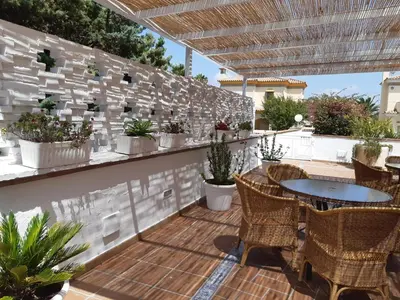 a patio with tables and chairs and potted plants at Hotel Marisma Sancti Petri in Chiclana de la Frontera