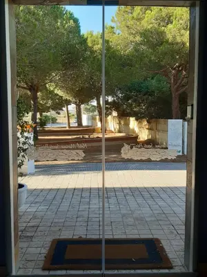 a view through a glass door into a courtyard at Hotel Marisma Sancti Petri in Chiclana de la Frontera