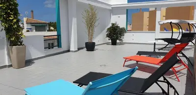 a patio with chairs and a table on a balcony at Hotel Los Nardos in Chipiona