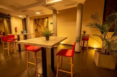 a restaurant with a wooden table and red chairs at Hotel Los Nardos in Chipiona