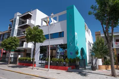 a building on a street with trees in front of it at Hotel Los Nardos in Chipiona