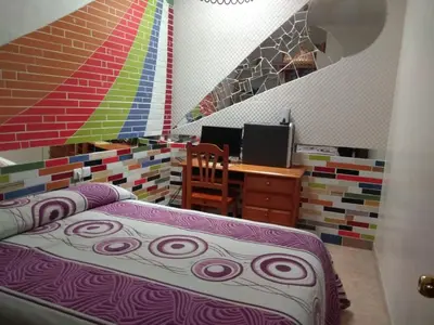 a bedroom with a bed and a desk with a computer at Downtown house centro histórico in Arcos de la Frontera